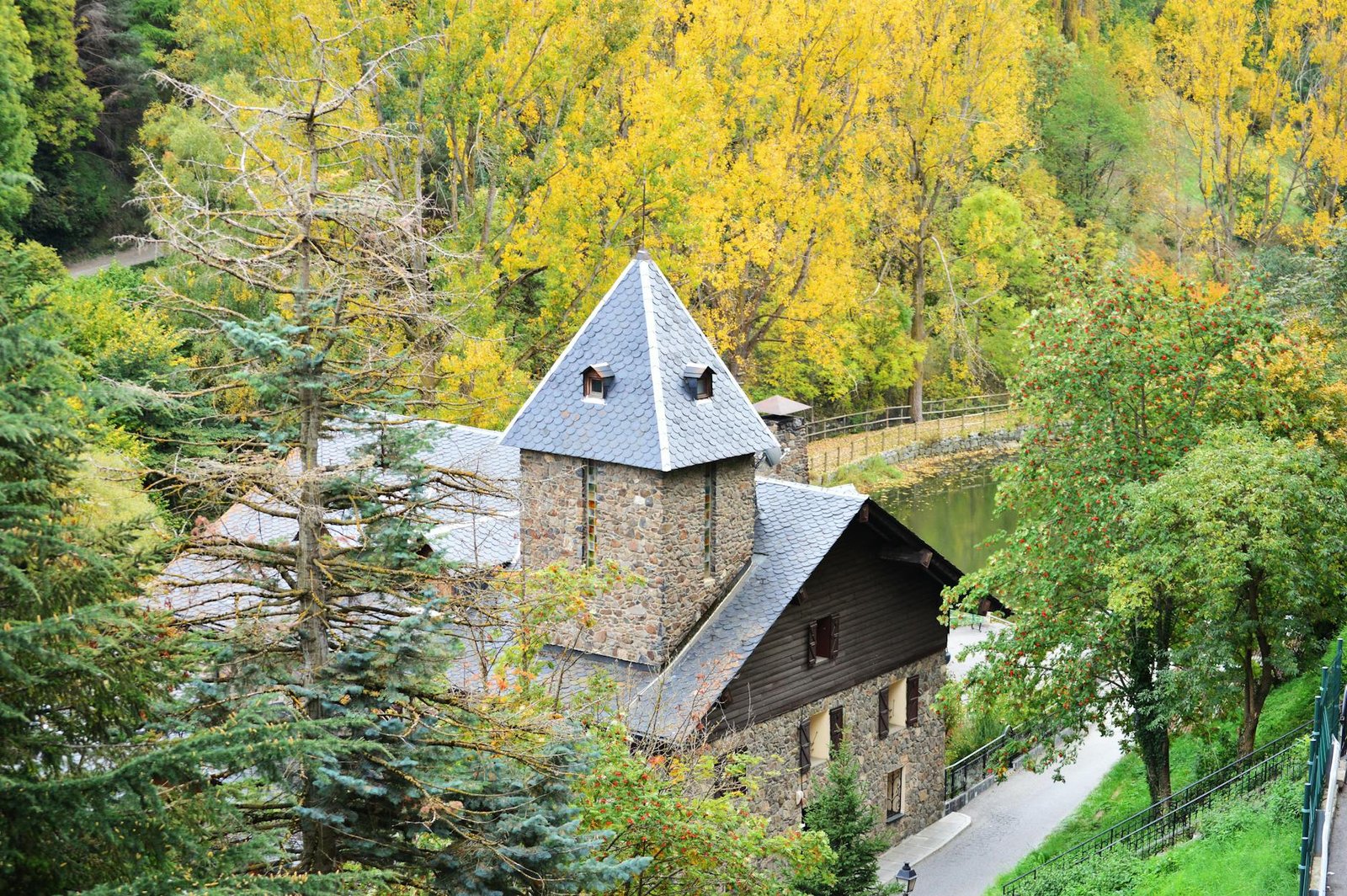 brown concrete house near the river surrounded by green trees