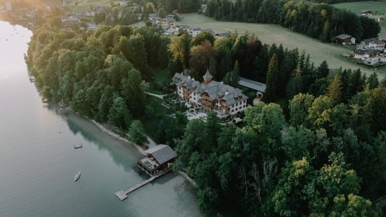 drone shot of a residence in the woods on the shore of lake wolfgang salzburg austria