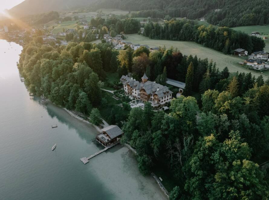 drone shot of a residence in the woods on the shore of lake wolfgang salzburg austria