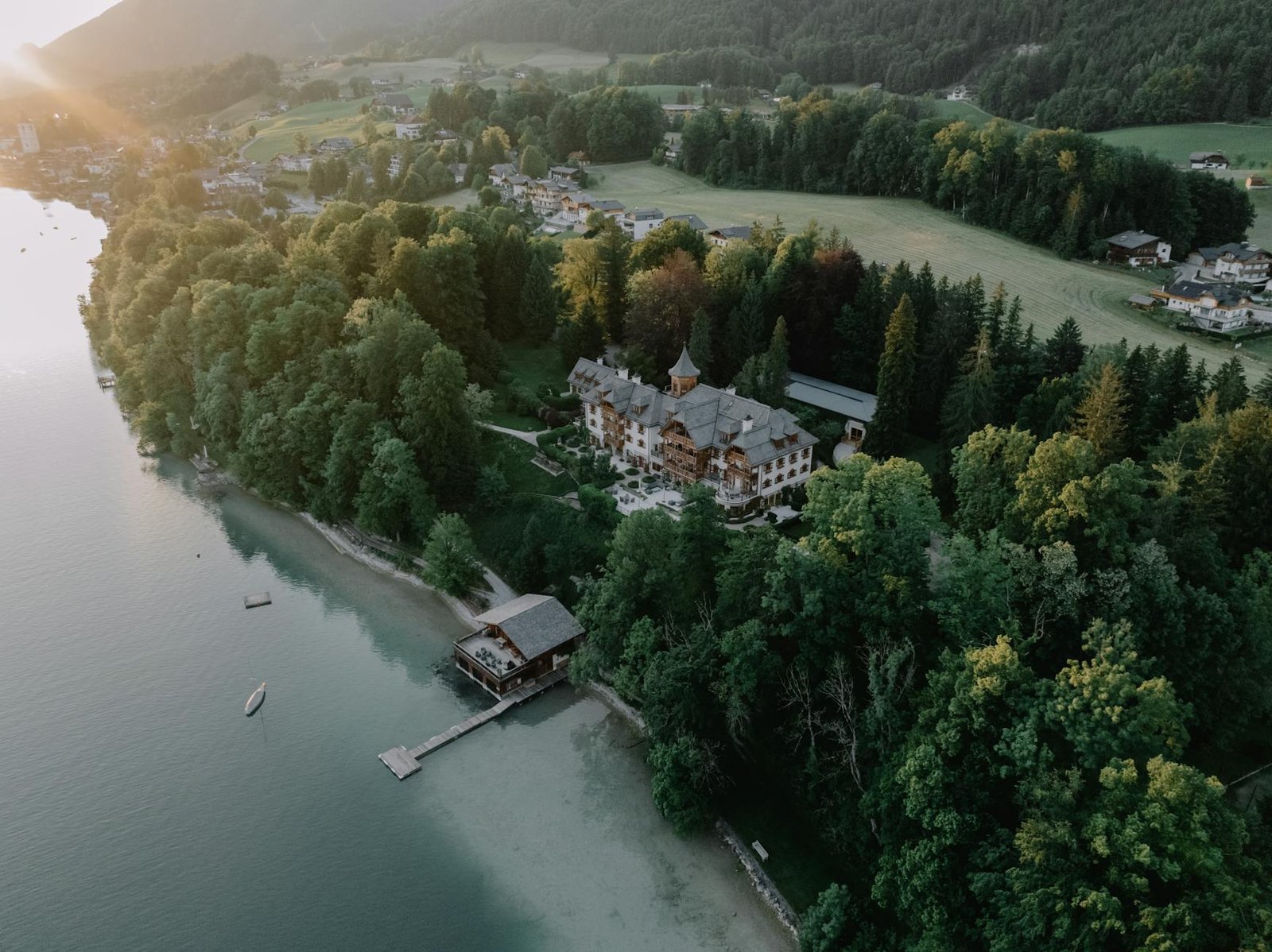 drone shot of a residence in the woods on the shore of lake wolfgang salzburg austria