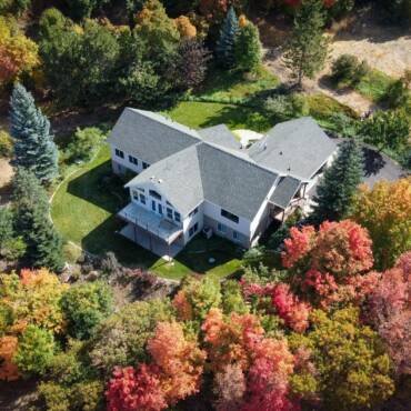 an aerial shot of a house surrounded by trees